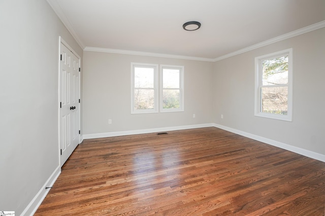 empty room with dark wood-type flooring, a wealth of natural light, and ornamental molding