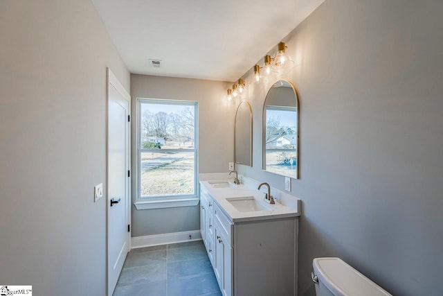 bathroom featuring toilet, vanity, and tile patterned flooring