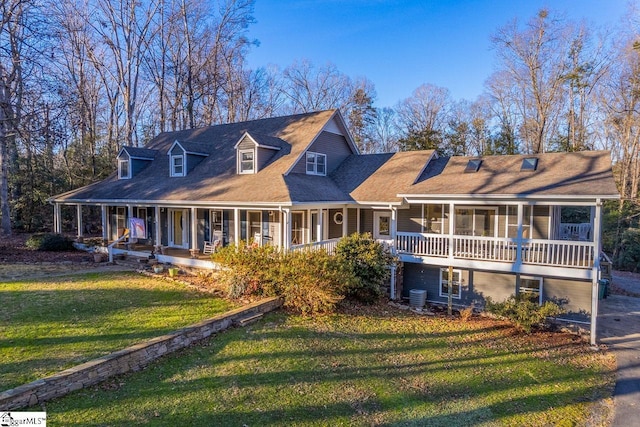 new england style home with a front lawn, a sunroom, cooling unit, and covered porch