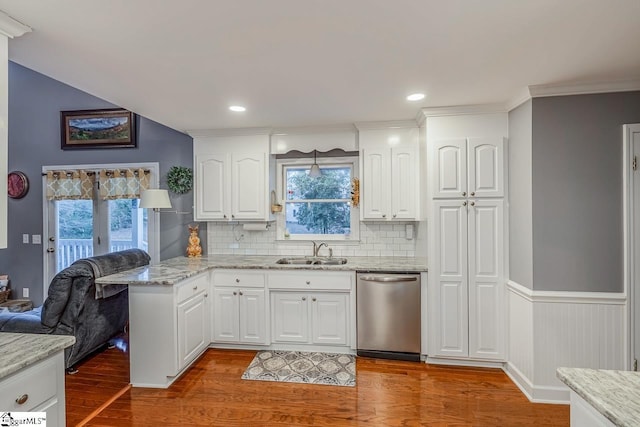 kitchen featuring stainless steel dishwasher, sink, and white cabinetry