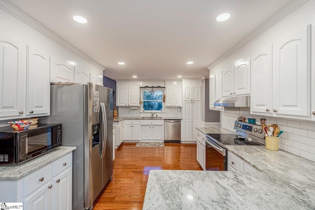 kitchen with sink, white cabinets, stainless steel appliances, and light wood-type flooring