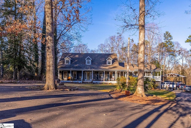 new england style home featuring a carport and covered porch