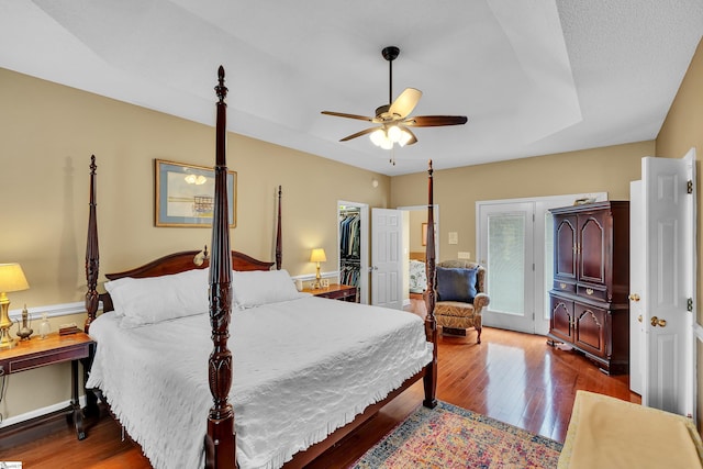 bedroom with a spacious closet, ceiling fan, a closet, and hardwood / wood-style floors