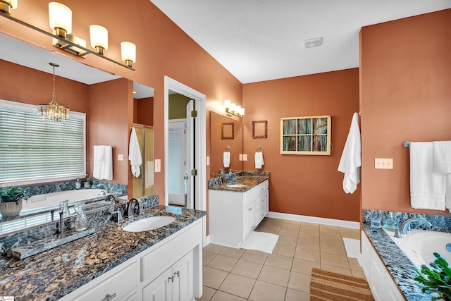 bathroom featuring vanity, tile patterned floors, a bathing tub, and a textured ceiling