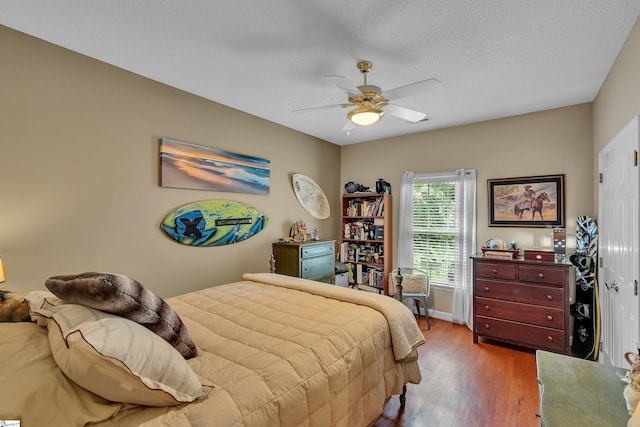 bedroom featuring ceiling fan, a textured ceiling, and hardwood / wood-style flooring