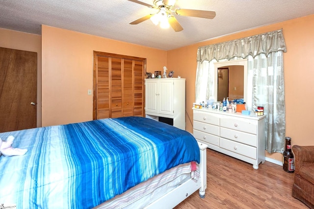 bedroom featuring a textured ceiling, ceiling fan, a closet, and wood-type flooring