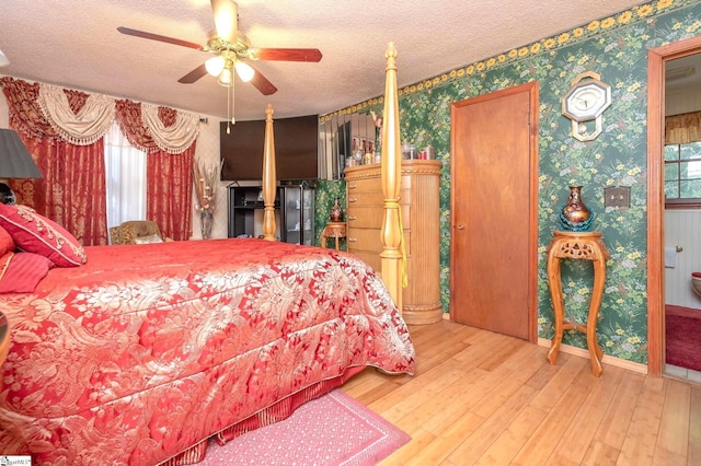 bedroom featuring hardwood / wood-style flooring, a textured ceiling, and ceiling fan