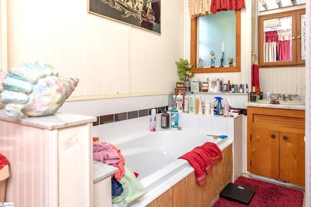 bathroom featuring a relaxing tiled tub and vanity