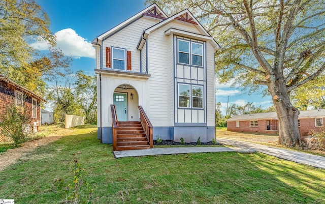 view of front of house featuring fence, board and batten siding, and a front yard