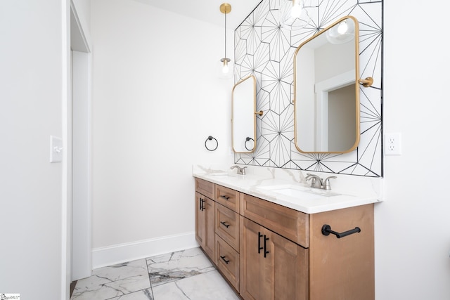 full bath with marble finish floor, a sink, baseboards, and double vanity