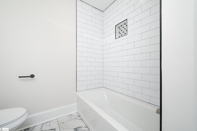 bathroom featuring toilet, marble finish floor, baseboards, and tub / shower combination