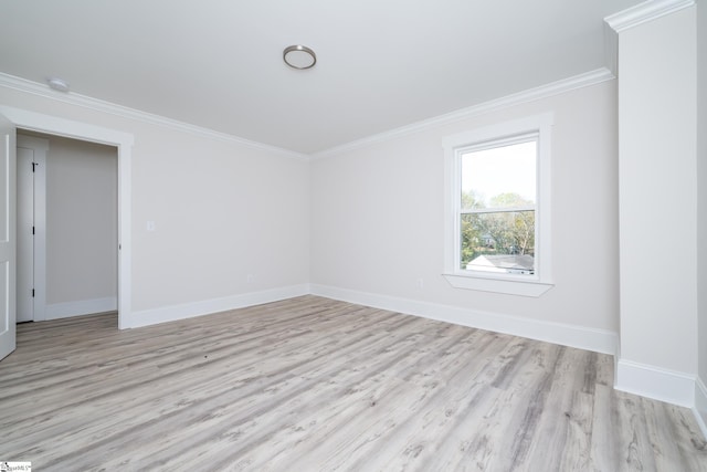 empty room with baseboards, crown molding, and light wood finished floors