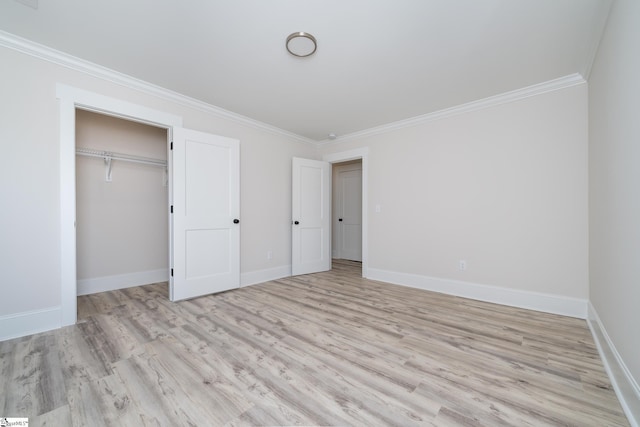 unfurnished bedroom featuring light wood finished floors, baseboards, ornamental molding, and a closet