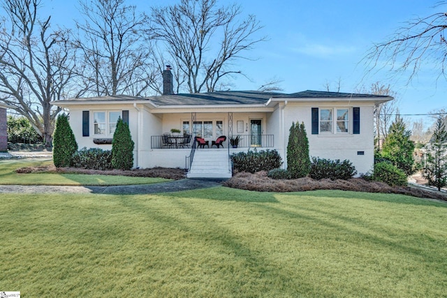 ranch-style home with covered porch and a front yard