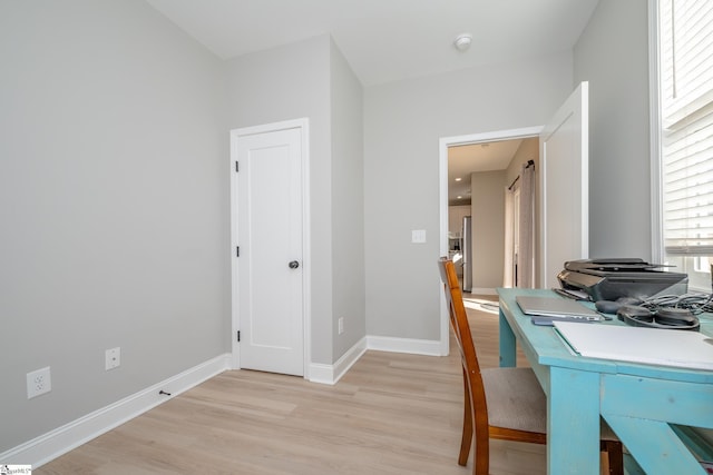 home office with light hardwood / wood-style floors