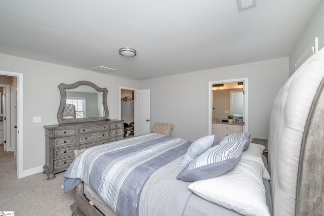 carpeted bedroom with a spacious closet and connected bathroom