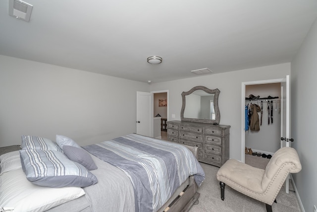 bedroom featuring light carpet, a walk in closet, and a closet