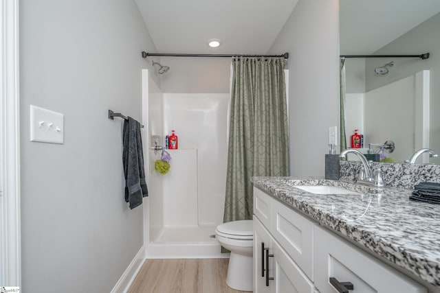 bathroom featuring curtained shower, hardwood / wood-style floors, toilet, and vanity