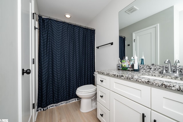 bathroom featuring toilet, hardwood / wood-style floors, and vanity