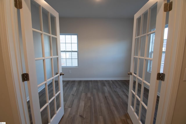 empty room with dark hardwood / wood-style flooring and french doors