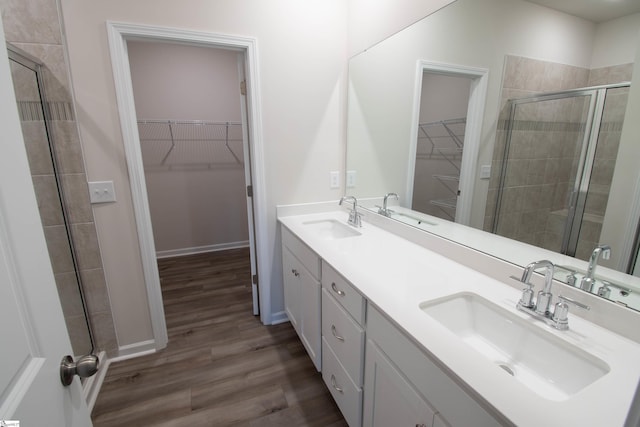 bathroom with hardwood / wood-style floors, an enclosed shower, and vanity