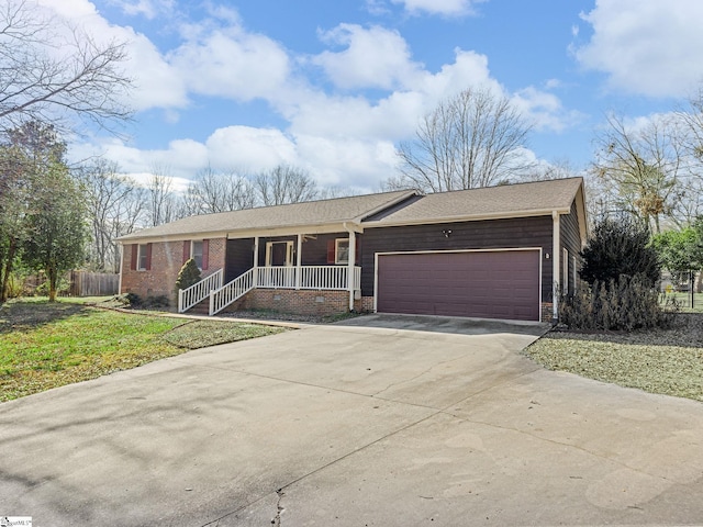 ranch-style home with a front lawn, covered porch, and a garage