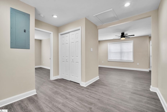 empty room with ceiling fan, hardwood / wood-style floors, and electric panel