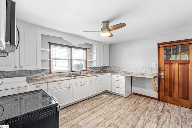 kitchen featuring white cabinetry, black range with electric stovetop, sink, ceiling fan, and light stone counters