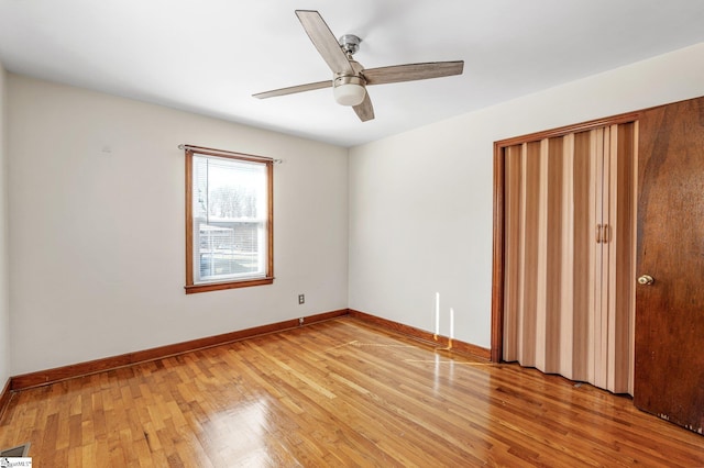 unfurnished bedroom with ceiling fan, wood-type flooring, and a closet