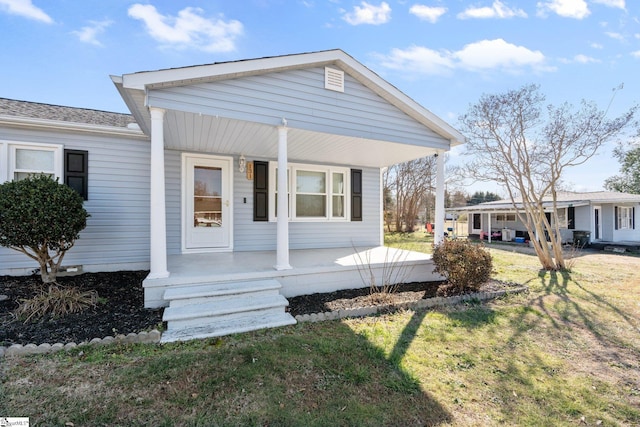 view of front of home with covered porch and a front lawn