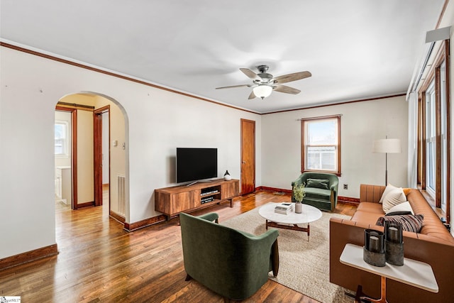 living room featuring ceiling fan, wood-type flooring, and crown molding