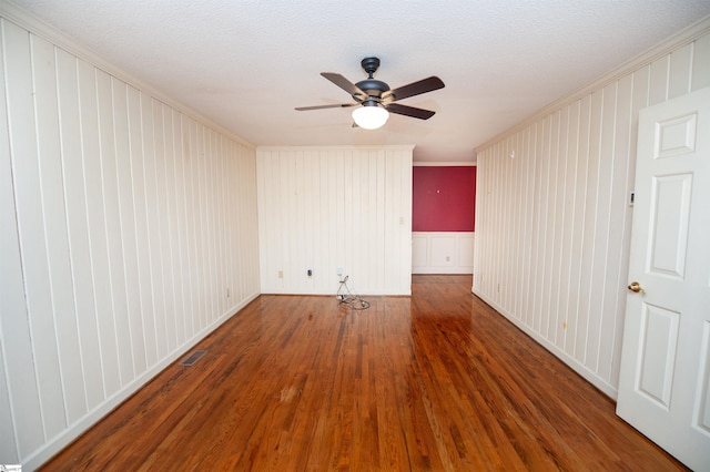 empty room with ornamental molding, a textured ceiling, ceiling fan, and dark hardwood / wood-style flooring