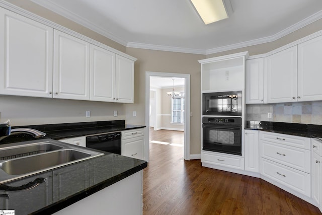 kitchen featuring white cabinets, black appliances, sink, ornamental molding, and a chandelier