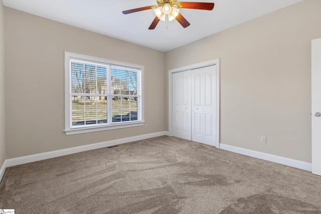 unfurnished bedroom with ceiling fan, a closet, and carpet