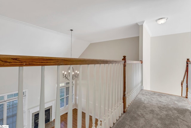 interior space featuring ornamental molding, lofted ceiling, carpet, and a notable chandelier