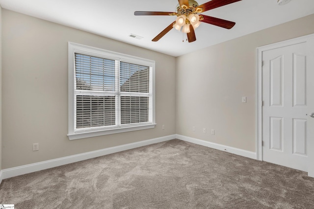 empty room featuring ceiling fan and light colored carpet