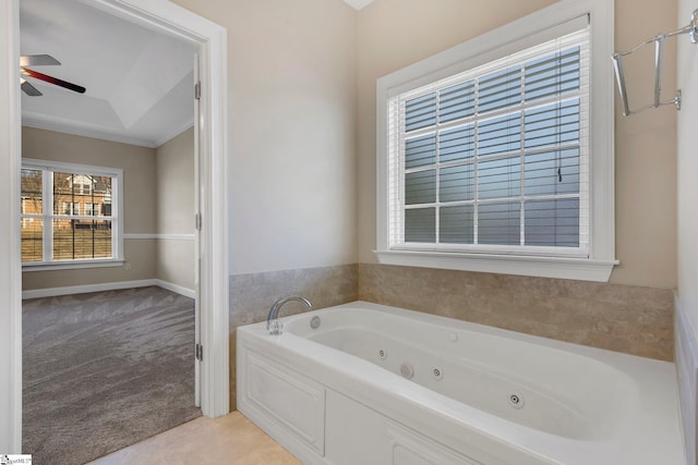 bathroom featuring ceiling fan, ornamental molding, a bathtub, and plenty of natural light