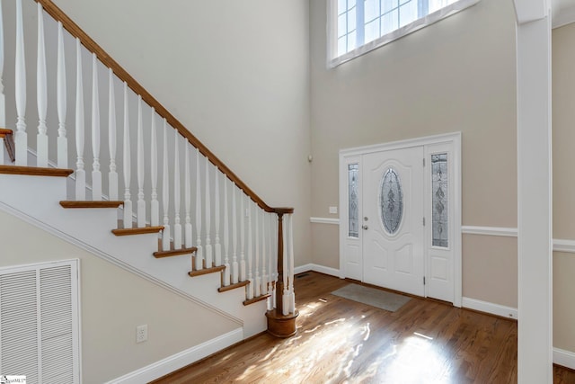 entrance foyer featuring a high ceiling and wood-type flooring