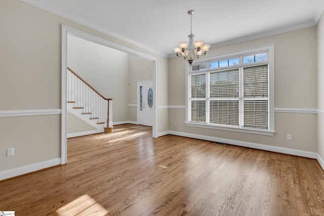 interior space with light hardwood / wood-style floors, a chandelier, and ornamental molding