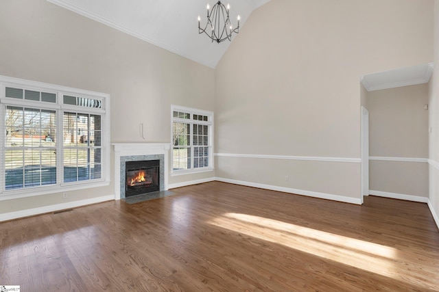 unfurnished living room with a fireplace, wood-type flooring, crown molding, high vaulted ceiling, and a chandelier