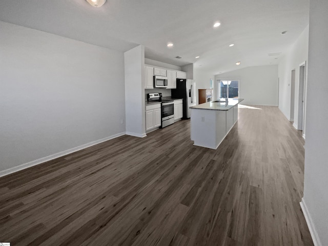 kitchen featuring white cabinets, a kitchen island, dark wood-type flooring, stainless steel appliances, and vaulted ceiling