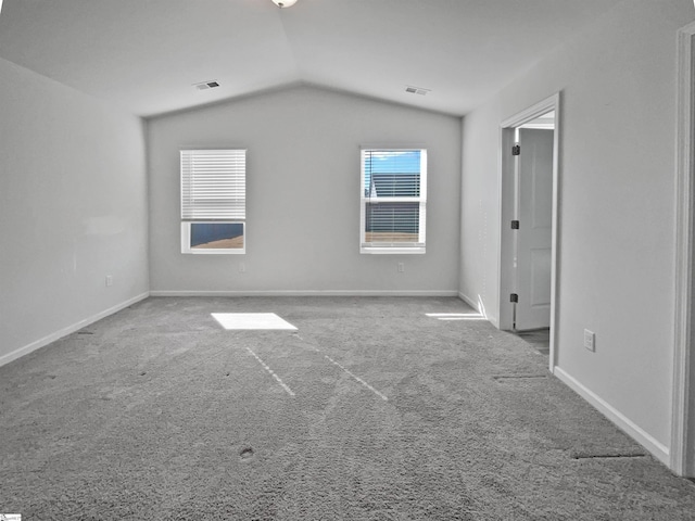 carpeted spare room featuring lofted ceiling