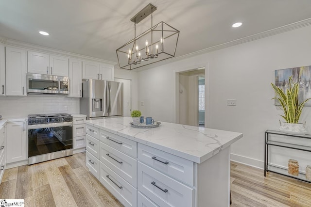 kitchen featuring appliances with stainless steel finishes, a kitchen island, decorative light fixtures, white cabinetry, and tasteful backsplash