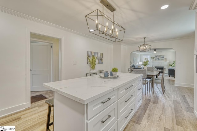 kitchen featuring ceiling fan, ornamental molding, white cabinetry, and pendant lighting