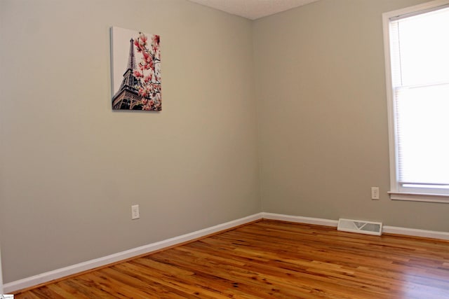 unfurnished room with hardwood / wood-style flooring