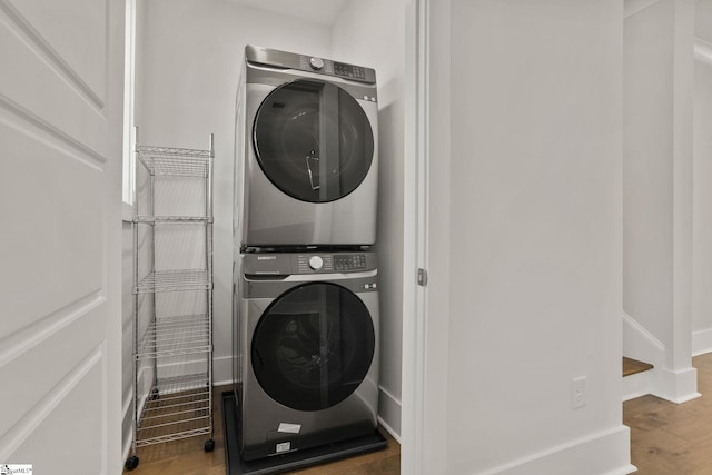 laundry room with stacked washing maching and dryer and wood-type flooring