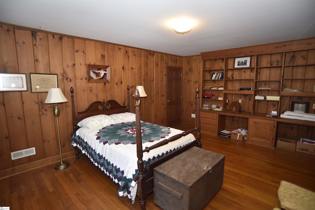 bedroom featuring wooden walls and dark hardwood / wood-style flooring