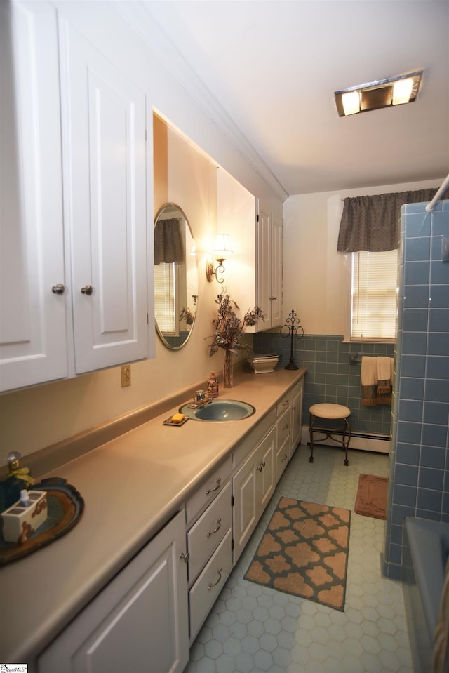 bathroom featuring vanity, crown molding, tile walls, and baseboard heating