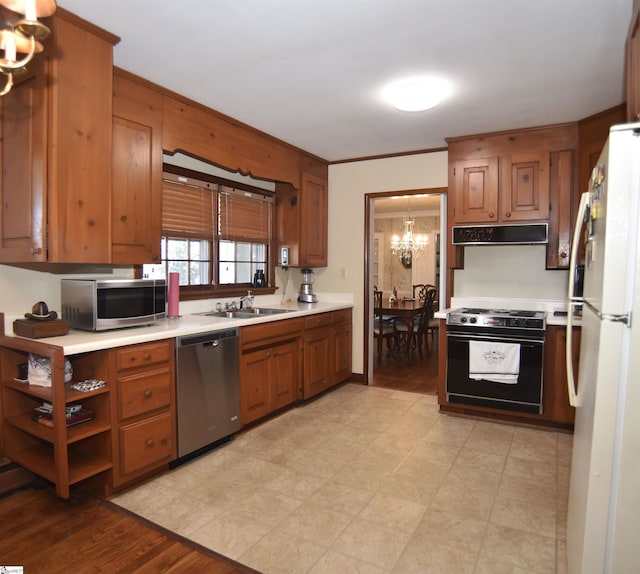 kitchen featuring crown molding, appliances with stainless steel finishes, sink, and a chandelier