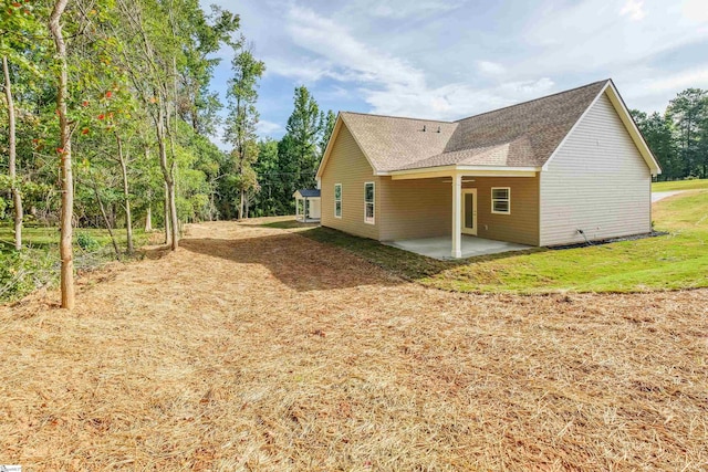 view of property exterior with a patio area and a lawn